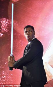 John Boyega with lightsaber promoting star wars